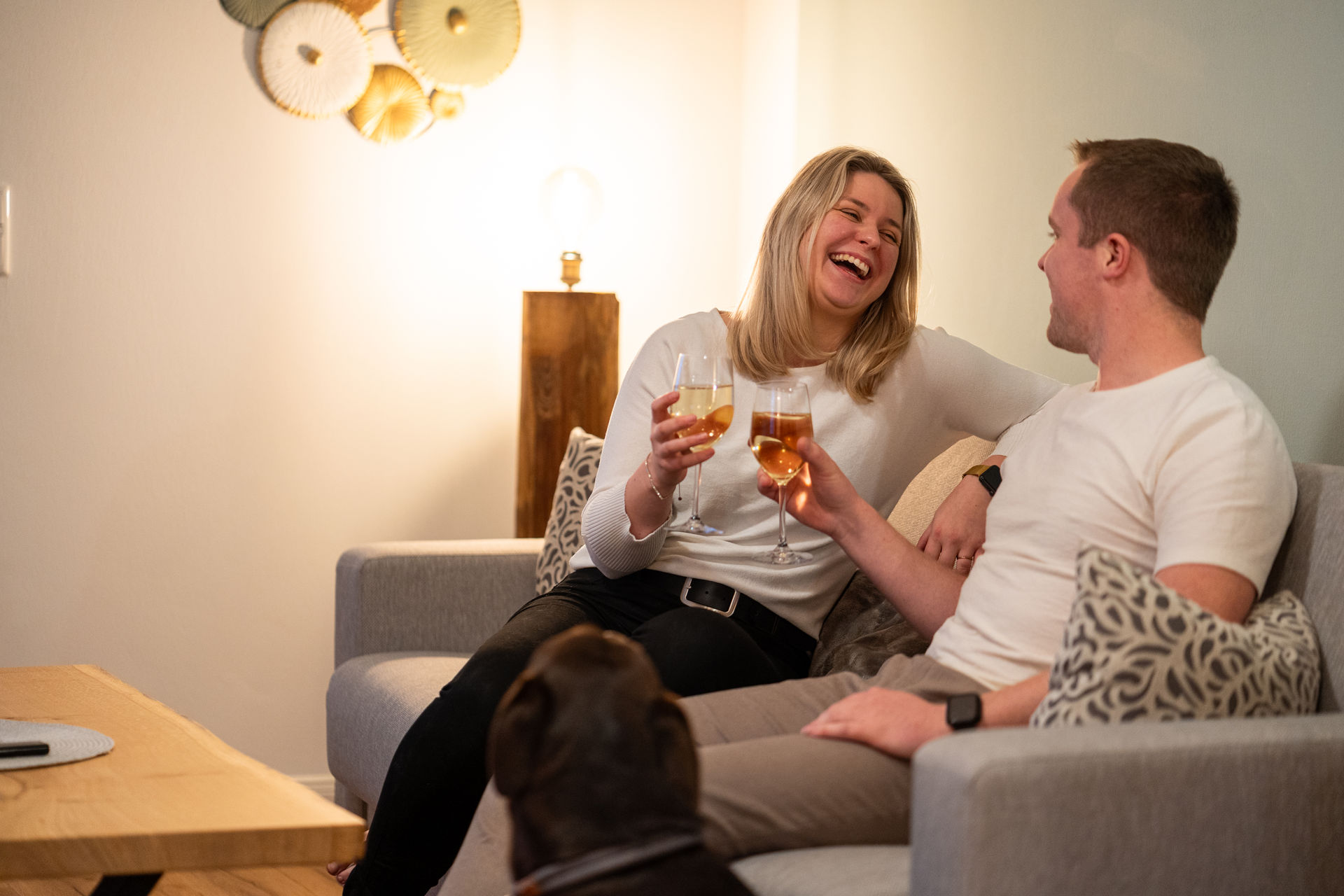 Junges Paar mit Weinglas auf dem Sofa in Wohnung 12 Radbod im Gulfhof Fresena in Norden, Ostfriesland